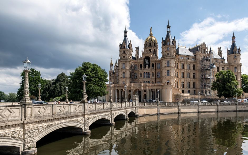 Stunning view of Schwerin Castle with its historic bridge and scenic surroundings in Germany.
