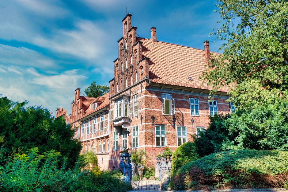 Charming view of Bergedorf Castle surrounded by lush greenery in Hamburg, Germany.